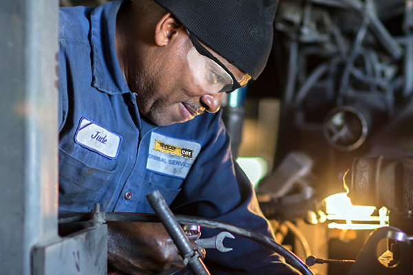 Yancey Engine Technician Performing Maintenance on Truck Engine